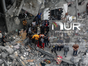 Palestinians are checking the damage in a house that was destroyed by an overnight Israeli bombardment in Nuseirat camp in the central Gaza...