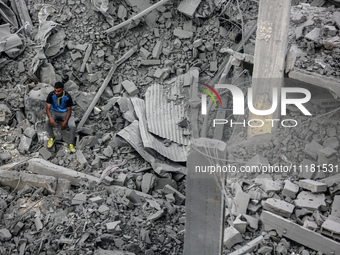 A Palestinian is inspecting the damage in a house that was destroyed by an overnight Israeli bombardment in Nuseirat camp in the central Gaz...