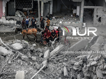 Palestinians are checking the damage in a house that was destroyed by an overnight Israeli bombardment in Nuseirat camp in the central Gaza...