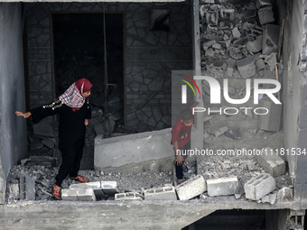 Palestinians are checking the damage in a house that was destroyed by an overnight Israeli bombardment in Nuseirat camp in the central Gaza...