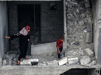 Palestinians are checking the damage in a house that was destroyed by an overnight Israeli bombardment in Nuseirat camp in the central Gaza...