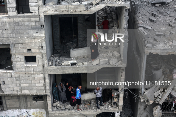 Palestinians are checking the damage in a house that was destroyed by an overnight Israeli bombardment in Nuseirat camp in the central Gaza...