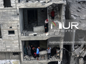 Palestinians are checking the damage in a house that was destroyed by an overnight Israeli bombardment in Nuseirat camp in the central Gaza...