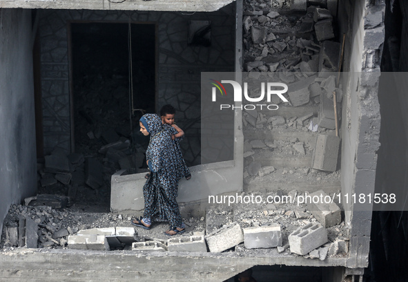 A Palestinian is inspecting the damage in a house that was destroyed by an overnight Israeli bombardment in Nuseirat camp in the central Gaz...