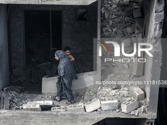 A Palestinian is inspecting the damage in a house that was destroyed by an overnight Israeli bombardment in Nuseirat camp in the central Gaz...