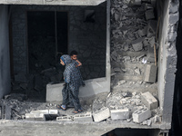 A Palestinian is inspecting the damage in a house that was destroyed by an overnight Israeli bombardment in Nuseirat camp in the central Gaz...