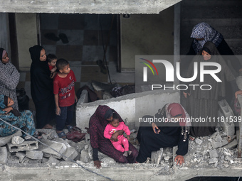 Palestinians are checking the damage in a house that was destroyed by an overnight Israeli bombardment in Nuseirat camp in the central Gaza...