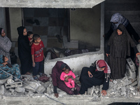 Palestinians are checking the damage in a house that was destroyed by an overnight Israeli bombardment in Nuseirat camp in the central Gaza...