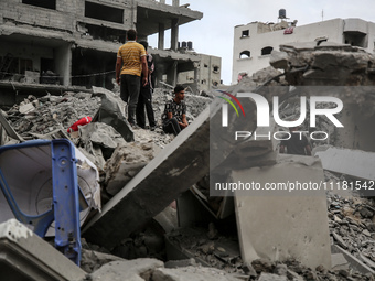 Palestinians are checking the damage in a house that was destroyed by an overnight Israeli bombardment in Nuseirat camp in the central Gaza...