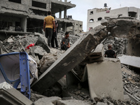 Palestinians are checking the damage in a house that was destroyed by an overnight Israeli bombardment in Nuseirat camp in the central Gaza...