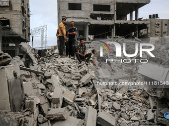 Palestinians are checking the damage in a house that was destroyed by an overnight Israeli bombardment in Nuseirat camp in the central Gaza...