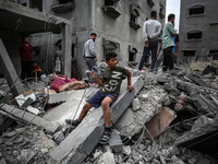 Palestinians are checking the damage in a house that was destroyed by an overnight Israeli bombardment in Nuseirat camp in the central Gaza...