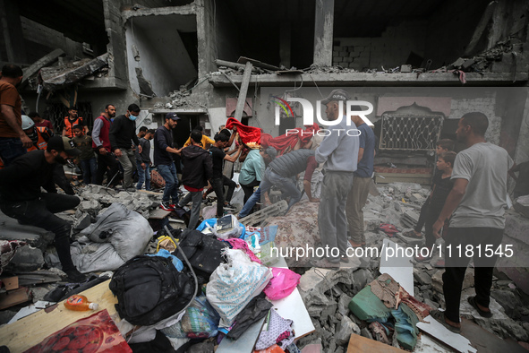 Palestinians are checking the damage in a house that was destroyed by an overnight Israeli bombardment in Nuseirat camp in the central Gaza...