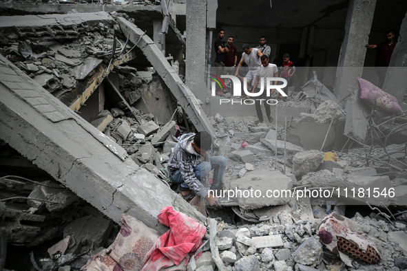 Palestinians are checking the damage in a house that was destroyed by an overnight Israeli bombardment in Nuseirat camp in the central Gaza...