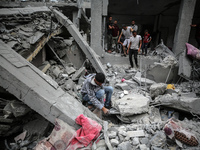 Palestinians are checking the damage in a house that was destroyed by an overnight Israeli bombardment in Nuseirat camp in the central Gaza...