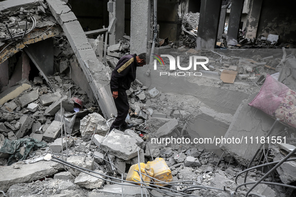 A Palestinian is inspecting the damage in a house that was destroyed by an overnight Israeli bombardment in Nuseirat camp in the central Gaz...