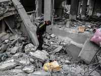 A Palestinian is inspecting the damage in a house that was destroyed by an overnight Israeli bombardment in Nuseirat camp in the central Gaz...