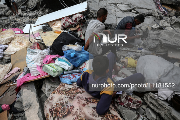 Palestinians are checking the damage in a house that was destroyed by an overnight Israeli bombardment in Nuseirat camp in the central Gaza...