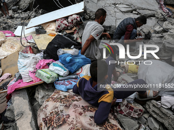 Palestinians are checking the damage in a house that was destroyed by an overnight Israeli bombardment in Nuseirat camp in the central Gaza...