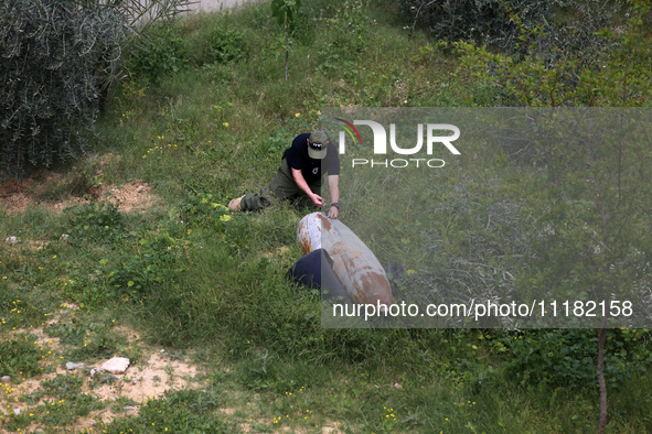 Simon Elmont from Humanity and Inclusion UK is examining and tagging large Israeli unexploded weapons to try to ensure maximum safety in Dei...