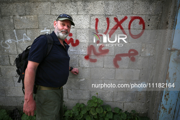 Simon Elmont from Humanity and Inclusion UK is examining and tagging large Israeli unexploded weapons to try to ensure maximum safety in Dei...