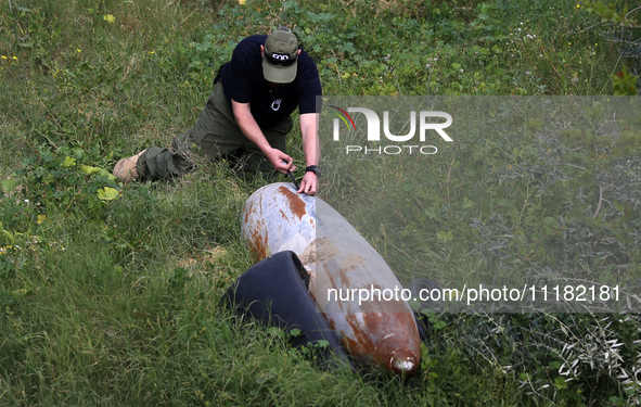 Simon Elmont from Humanity and Inclusion UK is examining and tagging large Israeli unexploded weapons to try to ensure maximum safety in Dei...