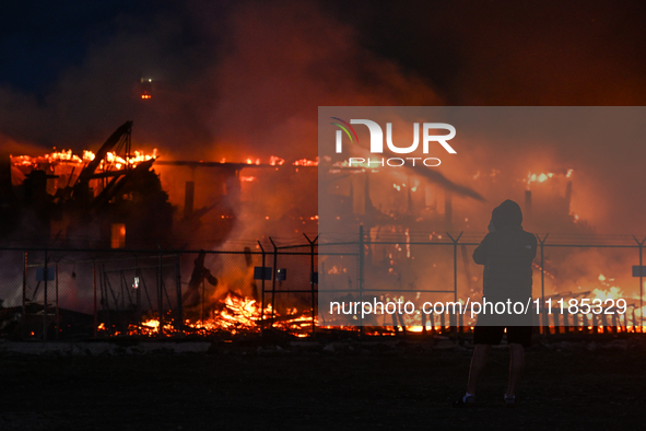 EDMONTON, CANADA - APRIL 22:
A person approaches the fire site, risking his health as several units of firefighters combat the flames that t...