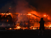 EDMONTON, CANADA - APRIL 22:
A person approaches the fire site, risking his health as several units of firefighters combat the flames that t...