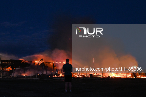 EDMONTON, CANADA - APRIL 22:
A person approaches the fire site, risking his health as several units of firefighters combat the flames that t...