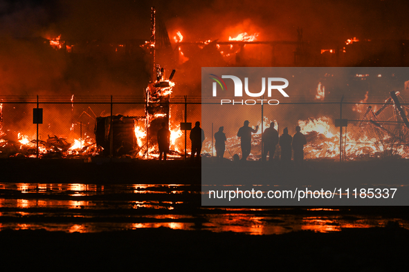 EDMONTON, CANADA - APRIL 22:
People approach the fire site, risking their health as several units of firefighters combat the flames that tor...