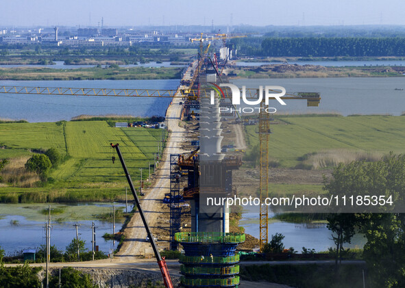 Workers are carrying out the construction of the steel pier bridge and the lower structure of the bridge across three river sections at the...