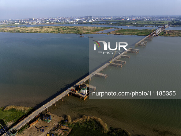 Workers are carrying out the construction of the steel pier bridge and the lower structure of the bridge across three river sections at the...