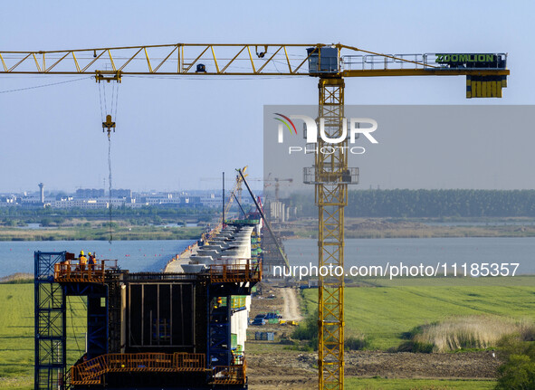 Workers are carrying out the construction of the steel pier bridge and the lower structure of the bridge across three river sections at the...