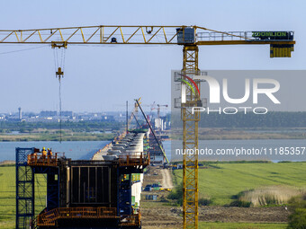 Workers are carrying out the construction of the steel pier bridge and the lower structure of the bridge across three river sections at the...