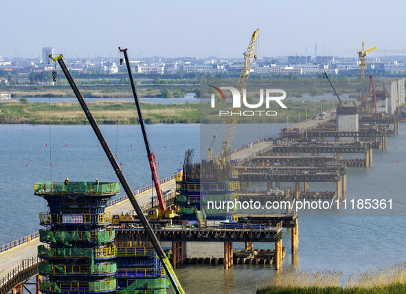 Workers are carrying out the construction of the steel pier bridge and the lower structure of the bridge across three river sections at the...