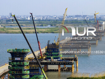 Workers are carrying out the construction of the steel pier bridge and the lower structure of the bridge across three river sections at the...