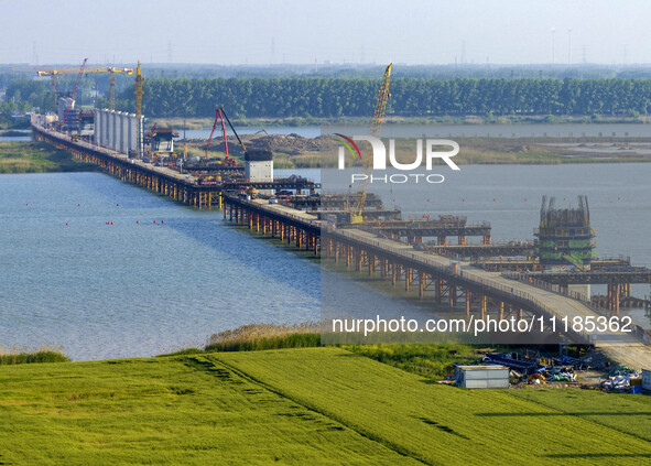 Workers are carrying out the construction of the steel pier bridge and the lower structure of the bridge across three river sections at the...