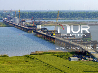 Workers are carrying out the construction of the steel pier bridge and the lower structure of the bridge across three river sections at the...