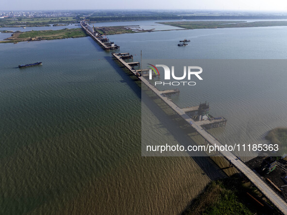 Workers are carrying out the construction of the steel pier bridge and the lower structure of the bridge across three river sections at the...