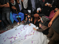 Palestinians are mourning by the bodies of relatives who were killed in an Israeli bombardment, at the al-Aqsa hospital in Deir Balah in the...