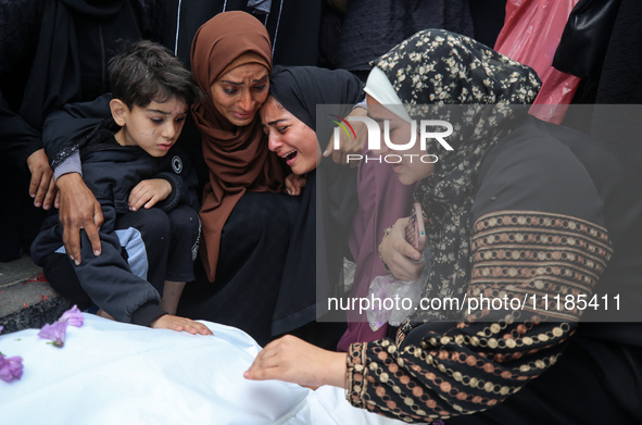 Palestinians are mourning by the bodies of relatives who were killed in an Israeli bombardment, at the al-Aqsa hospital in Deir Balah in the...