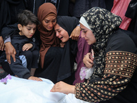 Palestinians are mourning by the bodies of relatives who were killed in an Israeli bombardment, at the al-Aqsa hospital in Deir Balah in the...