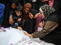 Palestinians are mourning by the bodies of relatives who were killed in an Israeli bombardment, at the al-Aqsa hospital in Deir Balah in the...