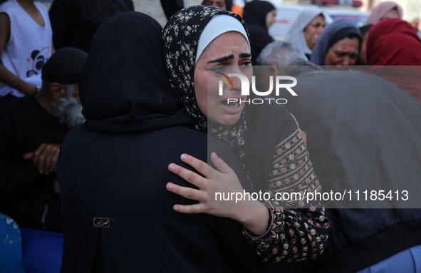 Palestinians are mourning by the bodies of relatives who were killed in an Israeli bombardment, at the al-Aqsa hospital in Deir Balah in the...