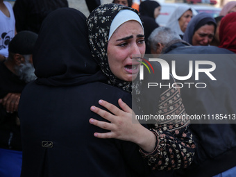 Palestinians are mourning by the bodies of relatives who were killed in an Israeli bombardment, at the al-Aqsa hospital in Deir Balah in the...