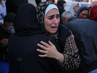 Palestinians are mourning by the bodies of relatives who were killed in an Israeli bombardment, at the al-Aqsa hospital in Deir Balah in the...