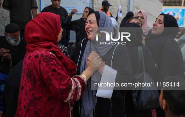 Palestinians are mourning by the bodies of relatives who were killed in an Israeli bombardment, at the al-Aqsa hospital in Deir Balah in the...