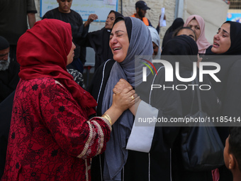 Palestinians are mourning by the bodies of relatives who were killed in an Israeli bombardment, at the al-Aqsa hospital in Deir Balah in the...