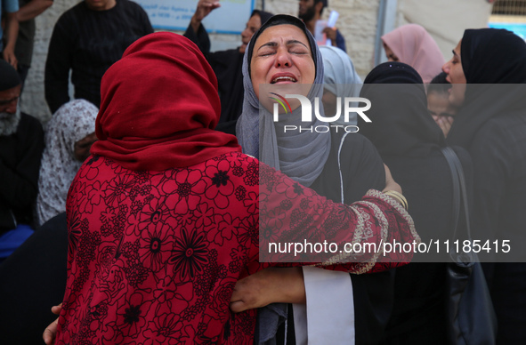 Palestinians are mourning by the bodies of relatives who were killed in an Israeli bombardment, at the al-Aqsa hospital in Deir Balah in the...