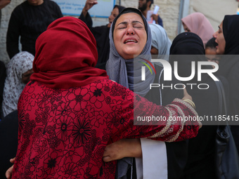 Palestinians are mourning by the bodies of relatives who were killed in an Israeli bombardment, at the al-Aqsa hospital in Deir Balah in the...